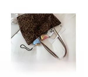 Vue détaillée de l'intérieur d'un grand sac cabas à imprimé léopard avec accessoires