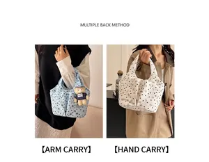 Detalle de bolsos de lona con flores en azul claro y beige con colgante de oso y bolsillos