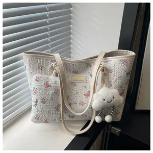 Detail of floral tote bag set showing jacquard fabric texture and cloud plush charm