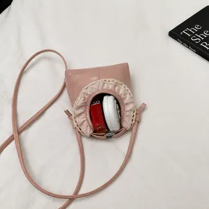 Internal capacity of pink mini crossbody bag showing storage for cosmetics and lipstick