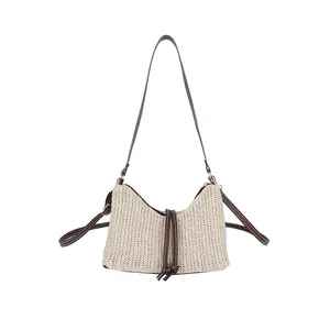 Elegante borsa a spalla in paglia intrecciata beige con finiture in pelle marrone e nappe