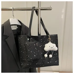 Close-up of black star pattern tote bag set with mini pouch and plush cloud charm