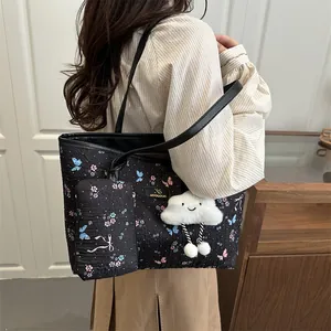 Black floral tote bag with butterfly patterns, small pouch and cloud charm pendant
