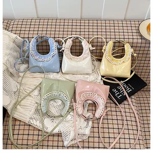 Flat lay of colorful mini lace-trimmed patent leather handbags in five pastel shades
