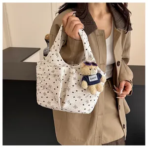 Dettaglio della borsa floreale in seersucker con stampa a cuore e ciondolo orsetto