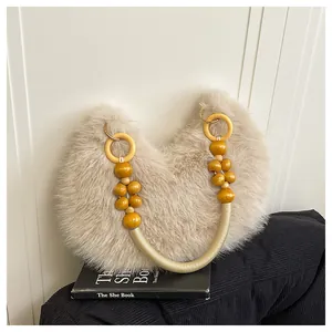 Detail of faux fur tote bag with wooden beads, braided rope handle and metal ring