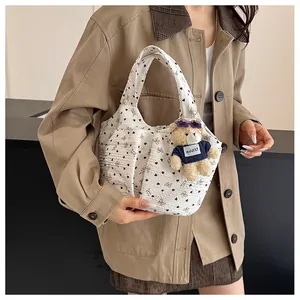 Dettaglio della borsa tote in tela floreale con cuori e ciondolo a orsetto