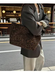 Vue de côté d'un sac cabas en suédine à imprimé léopard porté à l'épaule dans la rue