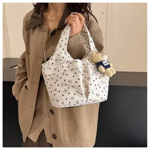 Dettaglio della borsa bianca con stampa a cuori e un simpatico ciondolo a forma di orso