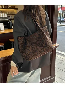 Vue détaillée du sac cabas en daim imprimé léopard porté à l'épaule dans la rue