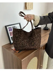 Détail du sac cabas à imprimé léopard en daim avec double bandoulière en cuir marron