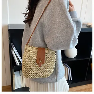 Detail van beige geweven emmertas met bruine lederen flap en retro metalen sluiting
