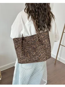 Grand sac cabas léopard en daim porté par un mannequin pour un look décontracté chic