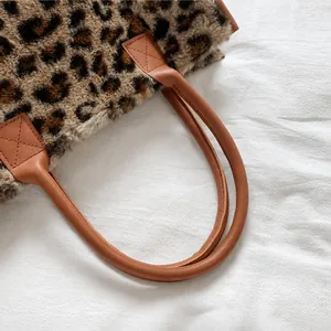 Detail showing comfortable faux leather handle and soft leopard plush tote bag texture