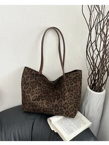 Détail du motif léopard et des bandoulières en cuir marron sur le grand sac cabas