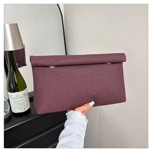 Gros plan sur la pochette tressée pour femme en cuir synthétique violet et détails dorés