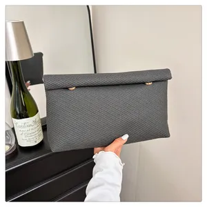 Vue détaillée de la pochette en tissu gris foncé avec des clous métalliques dorés