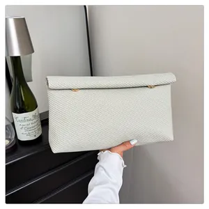 Vue détaillée d'une pochette enveloppe blanc cassé avec texture tissée diagonale
