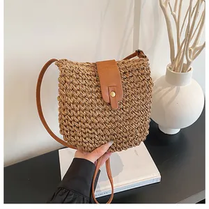 Detail van handgeweven papieren touw emmer tas met bruine leren riem en gouden sluiting