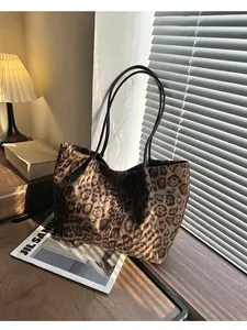 Détail du sac cabas en daim léopard avec bandoulière en cuir sous des ombres élégantes