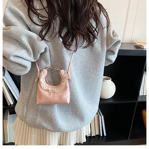 Detailed view of pink mini crossbody bag with ruffled lace and metal top handle