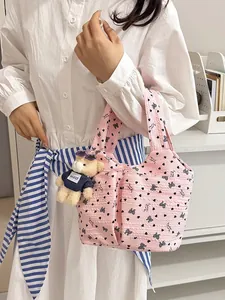 Borsa a mano rosa con motivi floreali, ciondolo a forma di orso e fiocchi decorativi