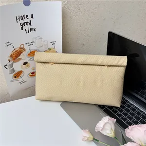 Pochette tissée beige minimaliste pour femme avec boucles dorées et finition texturée