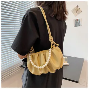 Dettaglio borsa a nuvola beige arricciata con catena di perle e tracolla in pelle