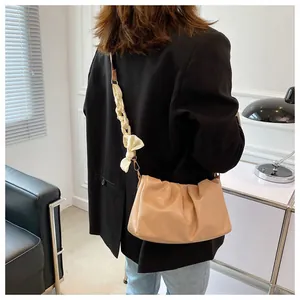 Dettaglio borsa a nuvola beige increspata con tracolla intrecciata e fiocco decorativo