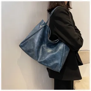 Détail macro du sac cabas vintage bleu marine en cuir avec bandoulières élégantes