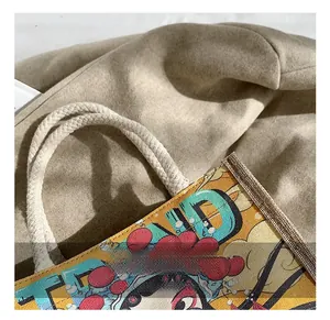 Detail showing the comfortable woven rope handle and printed fabric of the tote bag