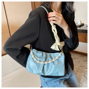 Dettaglio borsa a nuvola azzurra con catena di perle e decoro foulard in seta