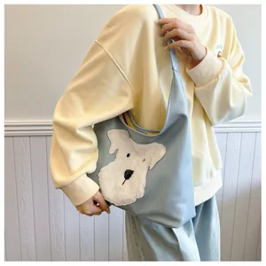 Dettaglio della borsa tote azzurra con ricamo a forma di cane in peluche su pelle PU liscia