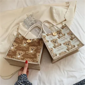 Linen tote bag with cartoon bear print and decorative wooden button on rope handle