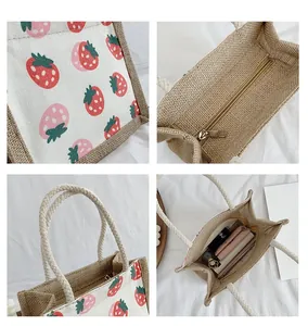 Detail showing strawberry print canvas tote bag with jute trim and rope handles