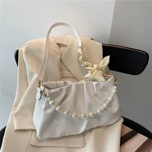 Elegante borsa a nuvola plissettata bianca con tracolla di perle e fiocco su abito