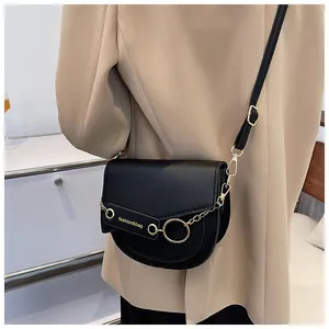 Dettaglio borsa a sella in pelle PU nera con anello dorato e catena decorativa