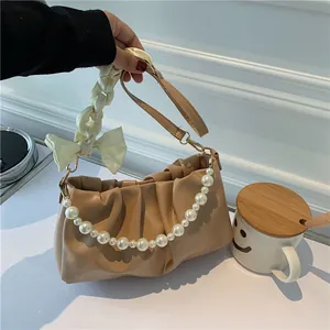Borsa cloud plissettata beige con catena di perle e dettaglio fiocco sulla tracolla