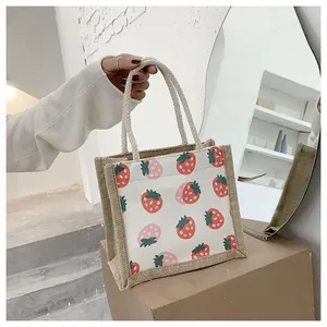 Detail of jute tote bag with strawberry print and soft cotton rope handles