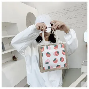 Detail of strawberry print linen handbag with natural jute trim and white rope handles