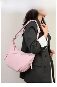 Close-up of pink corduroy crescent shoulder bag with stylish woven zipper detail
