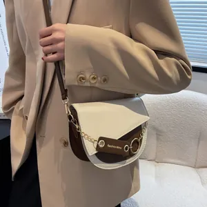 Borsa a tracolla stile sella bicolore con catena d'oro indossata da una modella