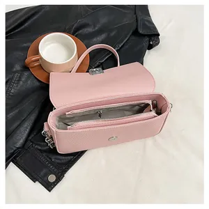 Internal detail of pink lychee leather bag with dual zipper pockets and silver lock
