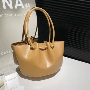 Borsa a secchiello in ecopelle marrone con pieghe e manico annodato stile tote minimalista