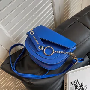Borsa a sella blu reale in ecopelle con anello metallico dorato e tracolla a catena
