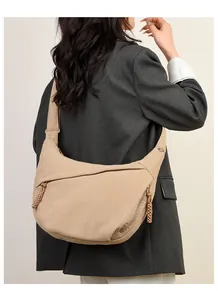 Detail view of light brown corduroy crescent bag showing texture and hand-woven zippers