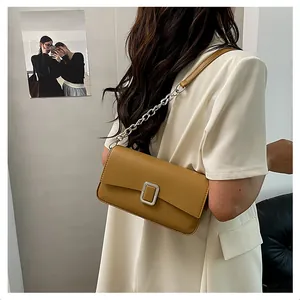 Close-up of the vintage brown leather shoulder bag featuring a silver metal square buckle