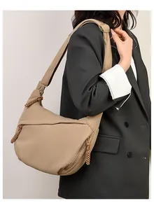 Detail of khaki corduroy texture and woven zipper pullers on the crescent shoulder bag
