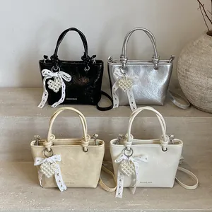 Minimalist square handbags in black, silver, and beige with pearl heart and lace bow charms