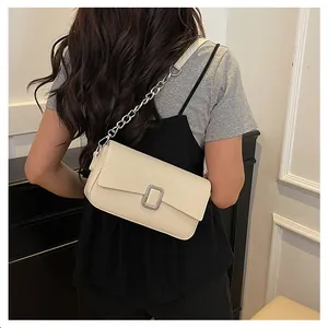 Close-up of cream white shoulder bag with silver buckle and chain leather strap